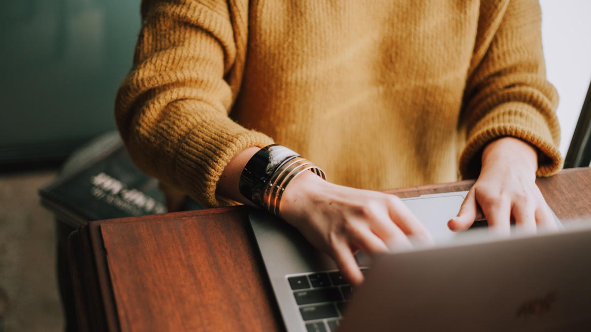 Person at a desk typing on a laptop