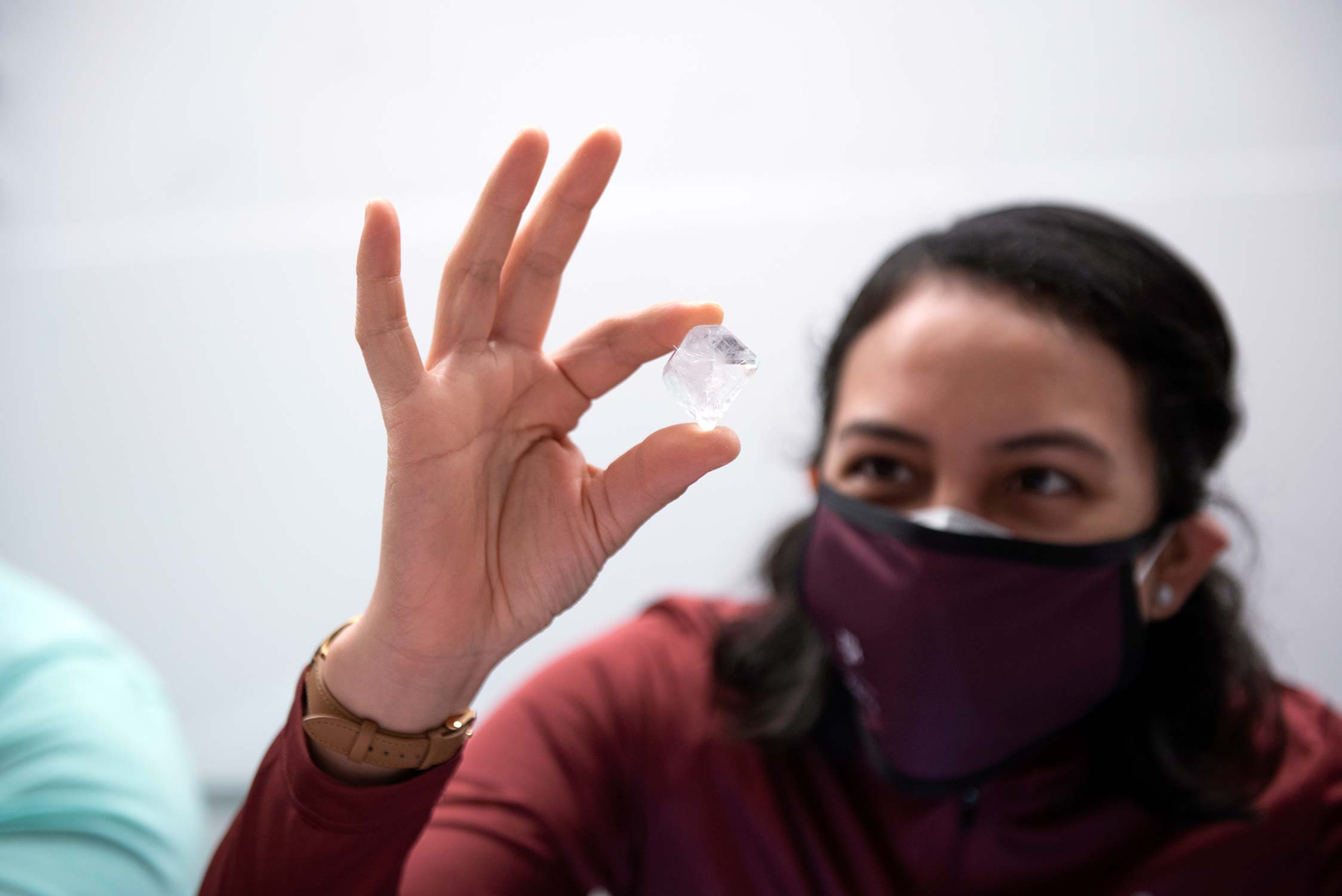 Texas A&amp;M chemistry graduate student Lupita Aguirre '22 takes a closer look at one of the nearly 170 crystal entries submitted for the 2021 U.S. Crystal Growing Competition., judged at Texas A&amp;M University