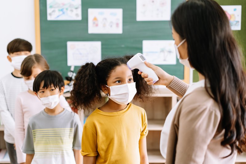 teacher temperature checking her student 