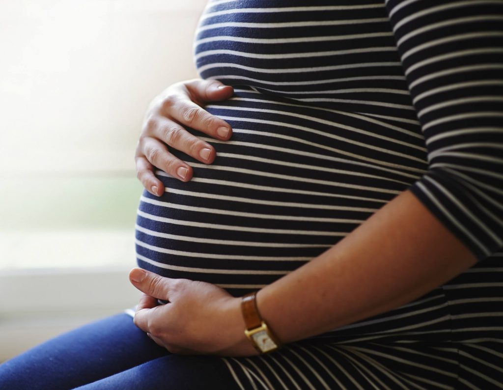 Pregnant woman holding her belly