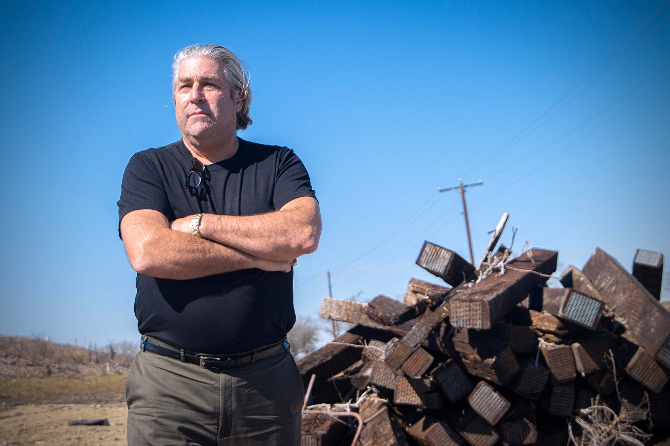 1990 Texas A&amp;M University chemistry Ph.D. graduate Carl McAfee, standing in front of a pile of discarded wooden railroad ties