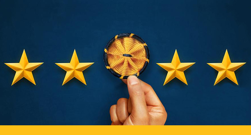 Four gold stars against a blue background featuring a hand holding the gold and blue American Association for the Advancement of Science rosette pin representing science and engineering, respectively