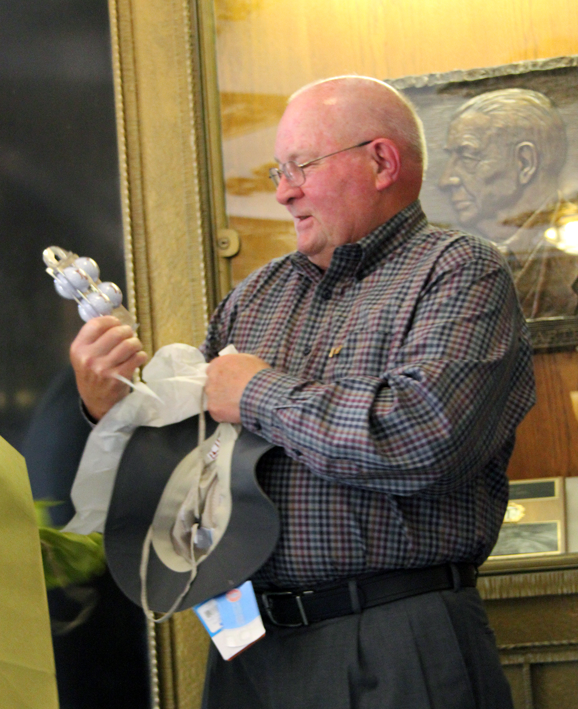 Texas A&amp;M chemist John Fackler admires a custom set of golf balls, one of several gifts he was presented with at his 80th birthday celebration in the Texas A&amp;M Chemistry Building.