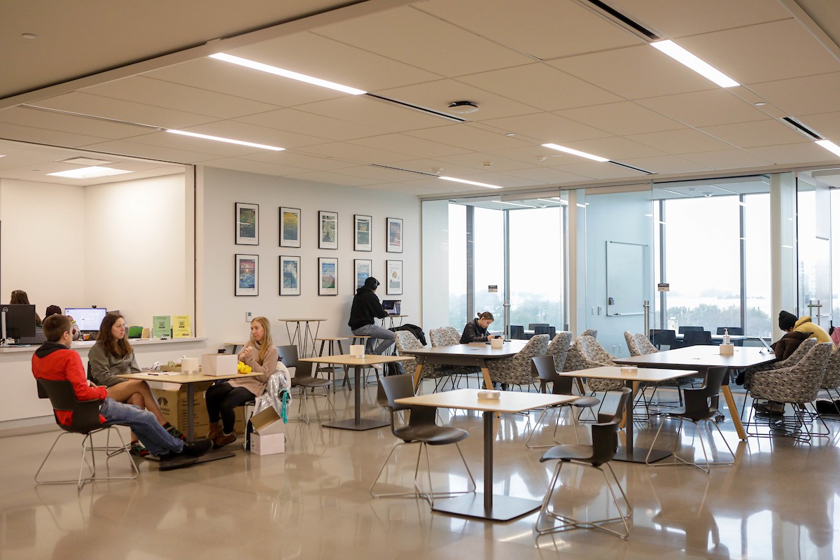 Students working at tables adjacent to chemistry help desk in the Instructional Laboratory and Innovative Learning Building at Texas A&amp;M University