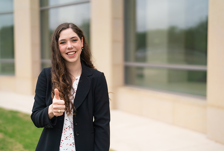 Texas A&amp;M senior Emily Orr flashes a gig 'em outside the Hagler Center