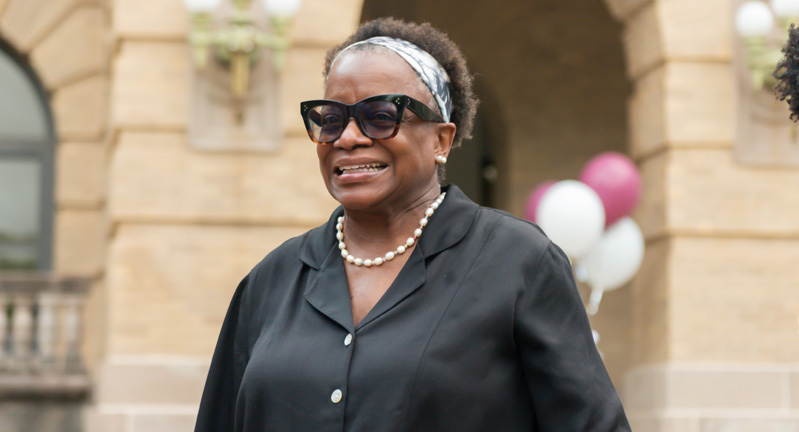 Texas A&M journalism program director Kathleen McElroy smiles while standing outside the Academic Building