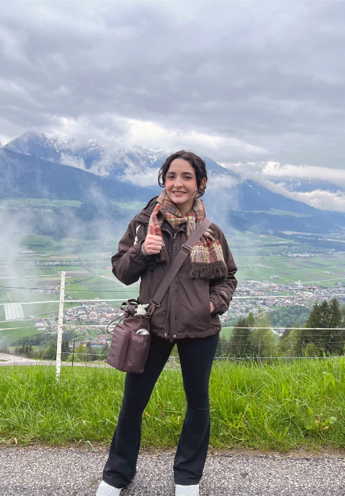 Texas A&amp;M meteorology student Taylor Peña flashes a gig 'em for the camera with the Alps in the background