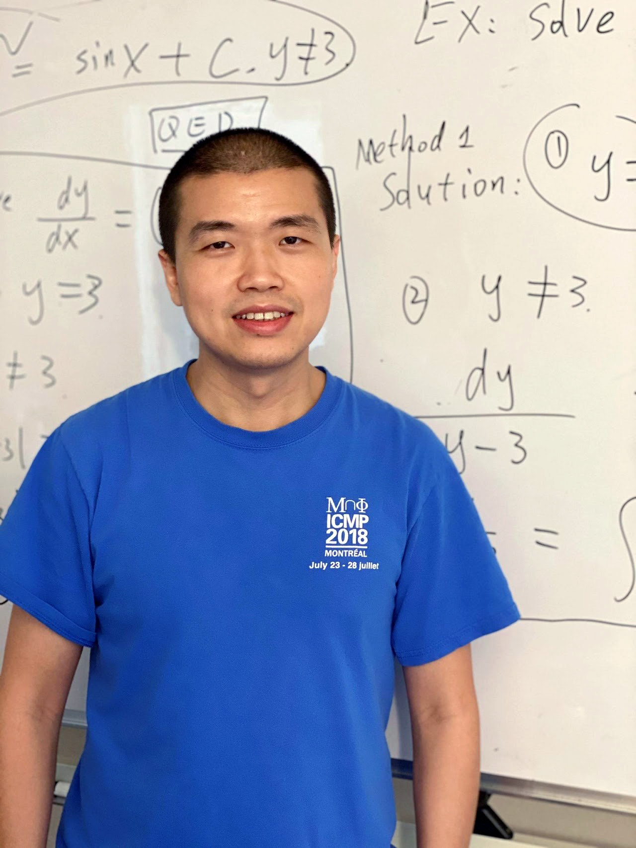 Texas A&amp;M University mathematician Wencai Liu, standing in front of a white board filled with hand-written mathematical formulas