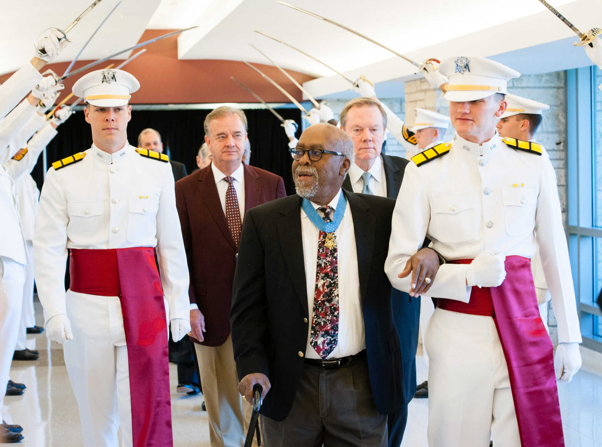 Texas A&amp;M University chemistry former student and Congressional Medal of Honor recipient Clarence Sasser, flanked by Ross Volunteers as he walks through the Memorial Student Center