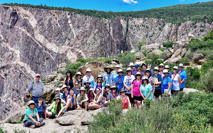 Group photograph of G-Camp participants with a canyon in the background