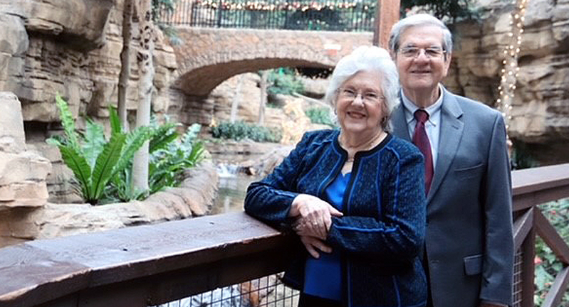 Patricia and Dr. William B. Smith '60, posing next to a railing overlooking a nature area