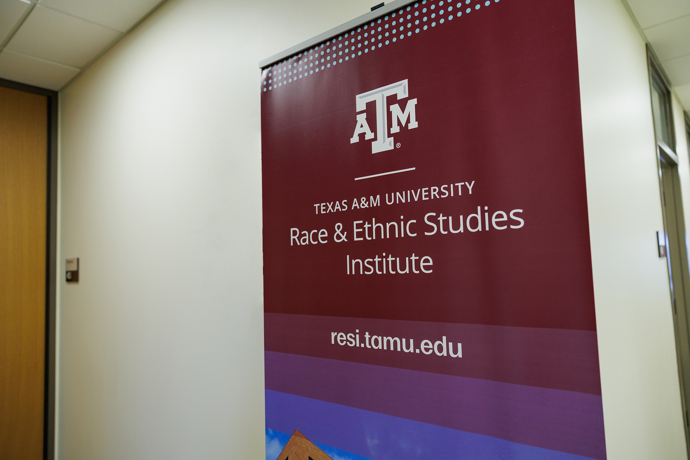 A pop-up banner for the Race and Ethnic Studies Institute stands against a classroom wall