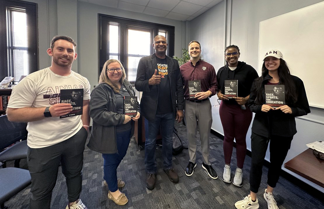 Texas A&amp;M University sport management professor John Singer (center) gives a thumbs up while standing with the five recipients of his book, "Race, Sports and Education," following his February 23, 2024, presentation about the book as a guest of the Texas A&amp;M Race and Ethnic Studies Institute