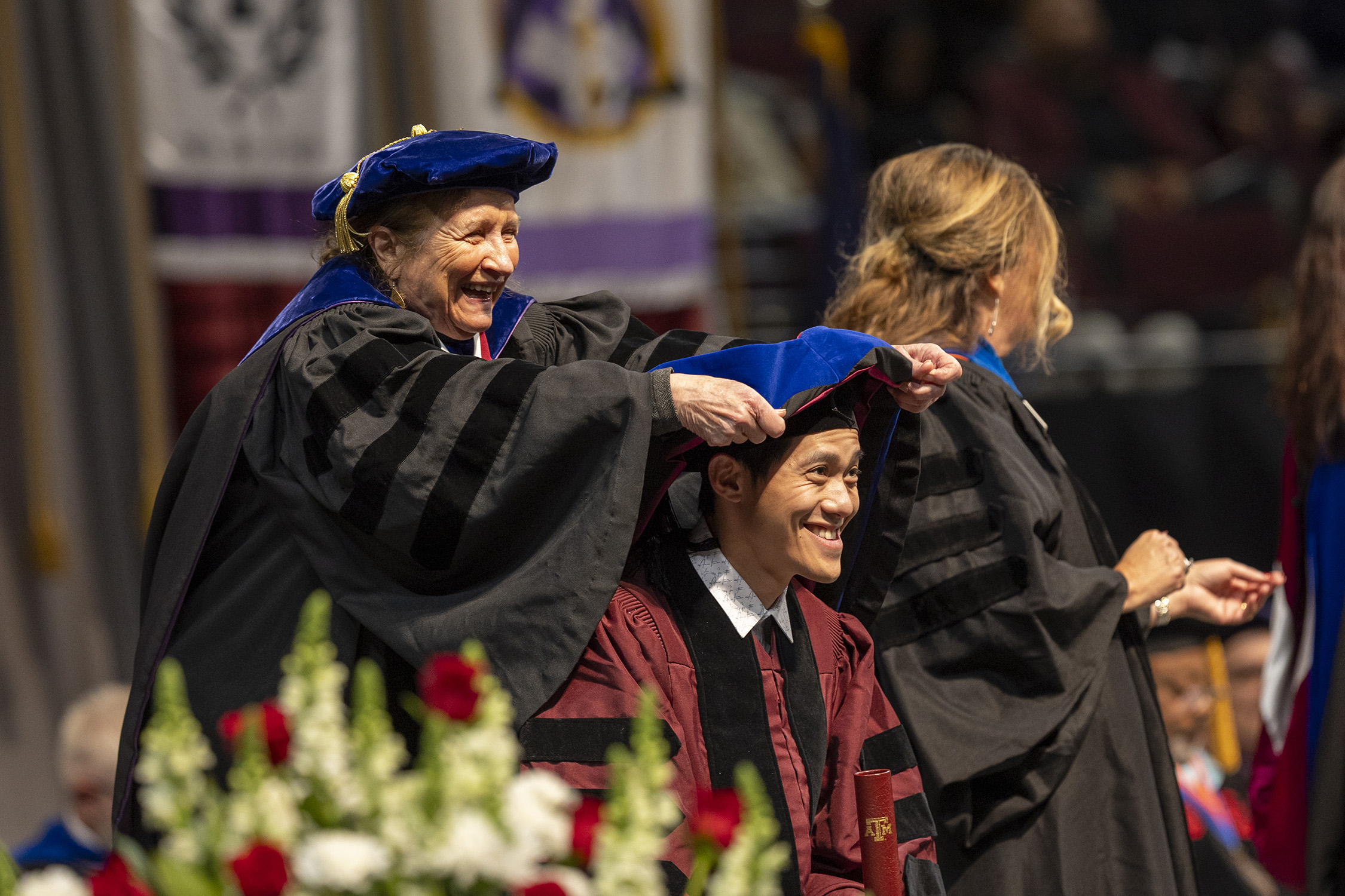 Texas A&amp;M University chemist Marcetta Darensbourg places a hood on one of her graduating doctoral students, Dr. Trung Le, during commencement ceremonies in Reed Arena on December 15, 2023